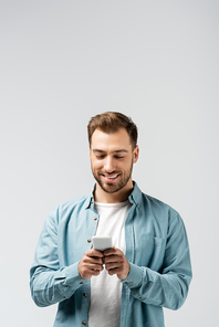 smiling young man using smartphone isolated on grey