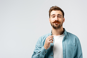 funny young man with fake mustache on stick isolated on grey