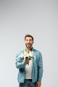 happy young man with floral bouquet isolated on grey