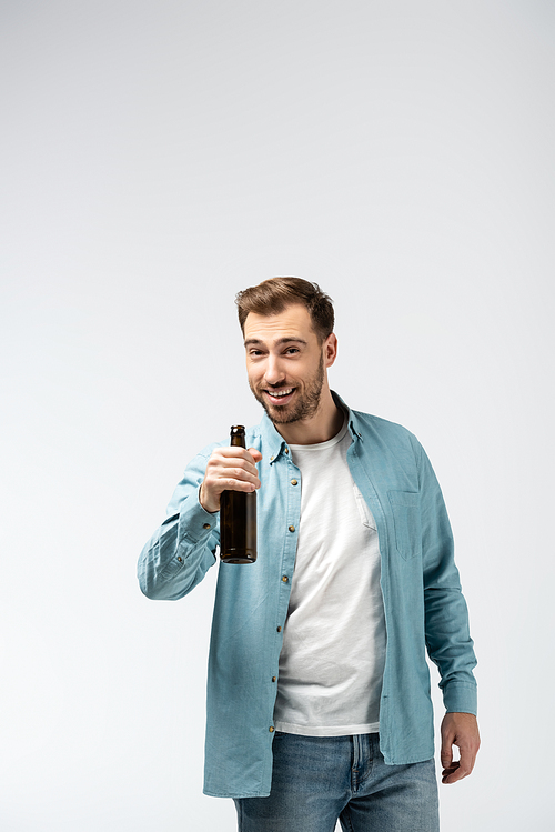 smiling young man with bottle of beer isolated on grey