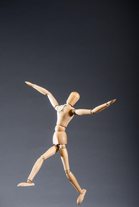 wooden marionette in tie on black background