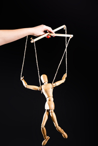 cropped view of puppeteer holding wooden marionette isolated on black