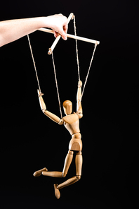 cropped view of puppeteer holding wooden marionette isolated on black