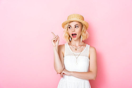 excited woman in straw hat having idea on pink
