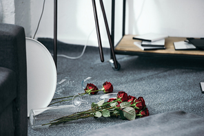 flowers and broken vase on floor in robbed apartment