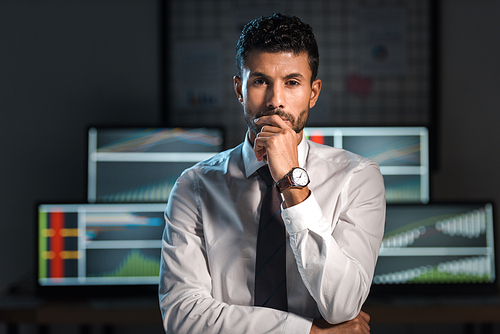 pensive and handsome bi-racial trader  in office