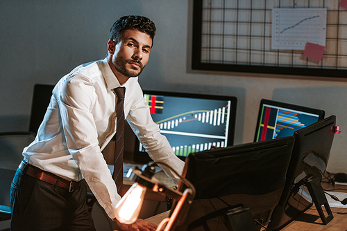 bi-racial trader standing near computers and 