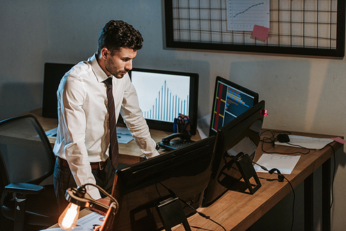 high angle view of bi-racial trader standing near computers in office