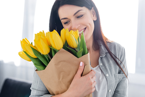 happy woman smiling and looking at tulips