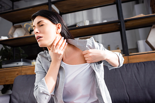 asthmatic woman with closed eyes touching neck