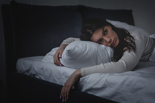 awake woman with insomnia lying on pillow at night