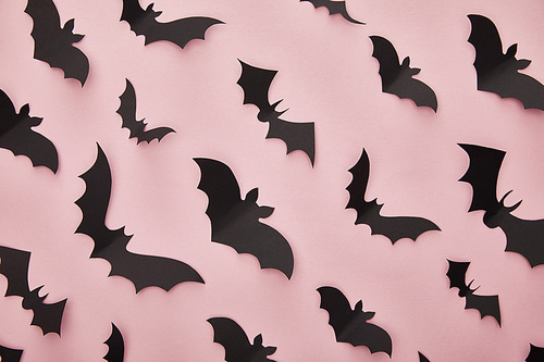 top view of paper bats on pink background, Halloween decoration