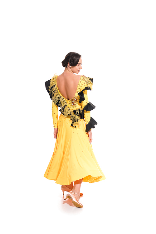 back view of elegant young ballroom dancer in yellow dress dancing isolated on white