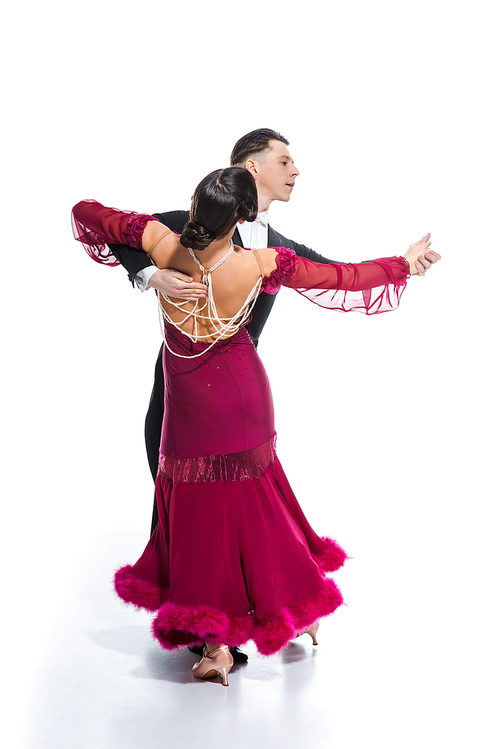 elegant young couple of ballroom dancers in red dress in suit dancing on white