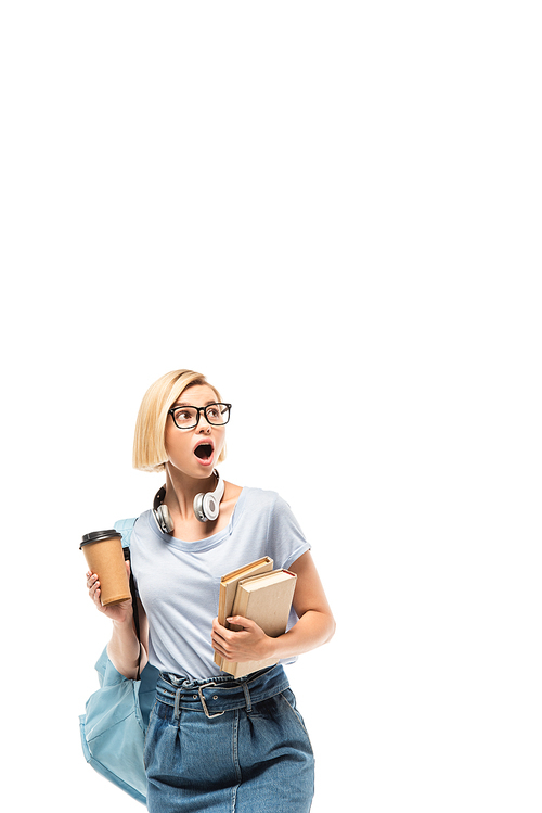 Shocked student holding coffee to go and books isolated on white