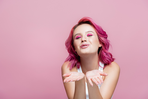 young woman with colorful hair blowing kiss isolated on pink