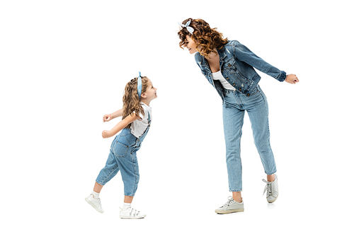mother and daughter in denim outfits looking at each other isolated on white