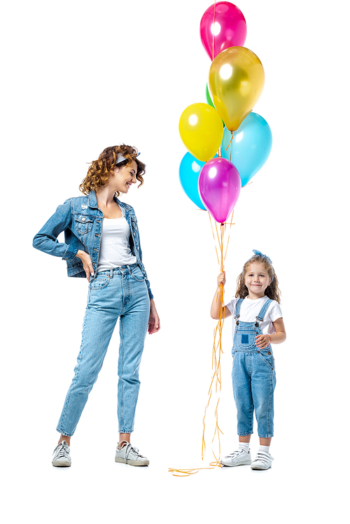 mother near daughter with colorful balloons isolated on white