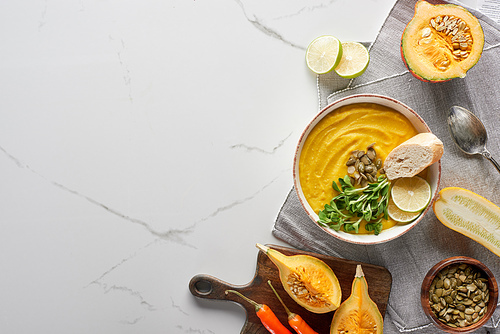 top view of autumnal mashed pumpkin soup on marble surface