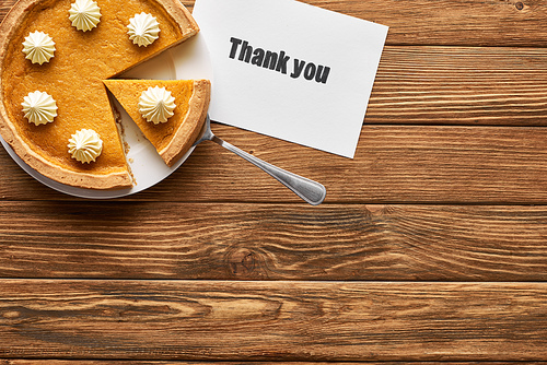 top view of tasty pumpkin pie and thank you card on wooden rustic table