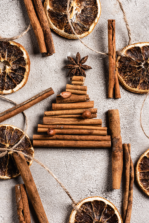Top view of cinnamon sticks in shape of pine with anise star on grey background