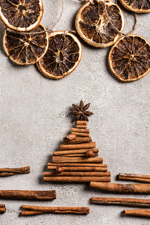 Top view of cinnamon sticks in shape of pine with anise star on grey background