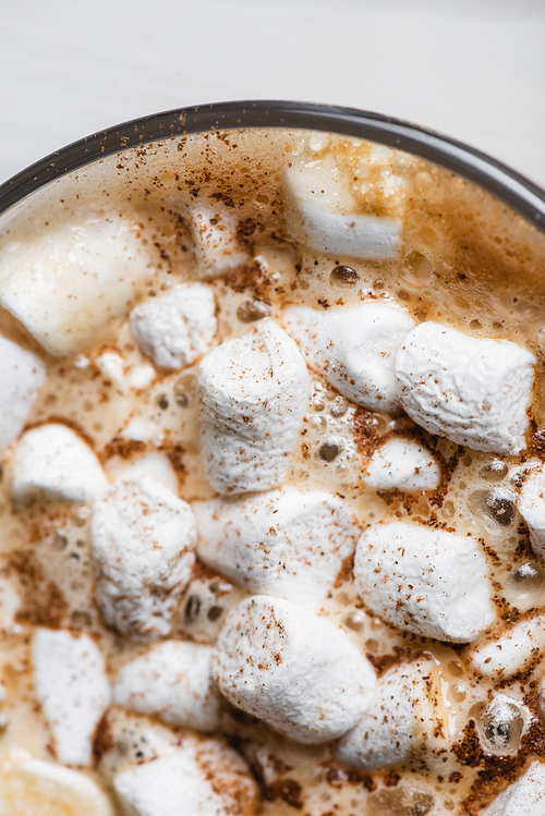 Close up view of cup of cocoa with marshmallows and cinnamon