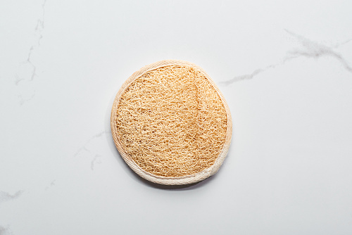 top view of natural face sponge on marble surface