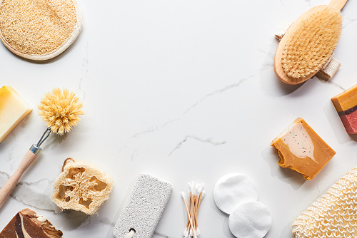 top view of homemade soap and bathroom accessories on marble surface with copy space