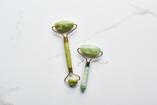 top view of nephrite massage rollers on marble surface