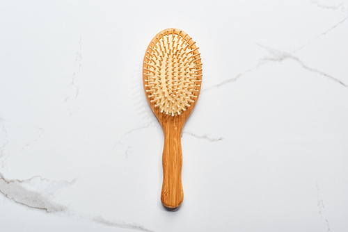 top view of wooden hair brush on marble surface