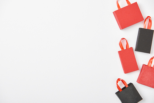 top view of black and red shopping bags on white background