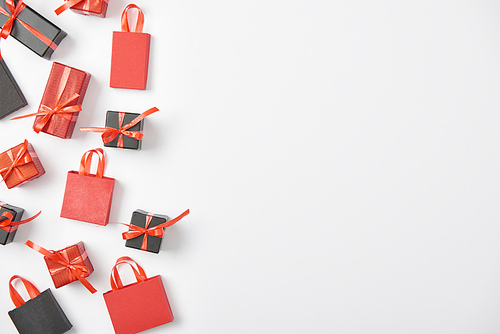 top view of black and red presents and shopping bags on white background