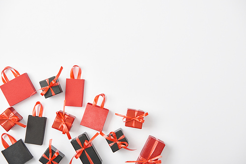 top view of black and red presents and shopping bags on white background with copy space