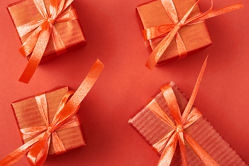 top view of gift boxes with bows and ribbons on red background