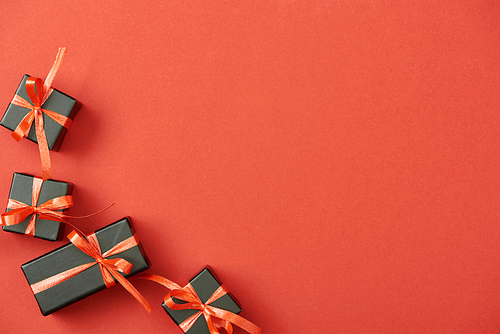 top view of small black gift boxes on red background with copy space