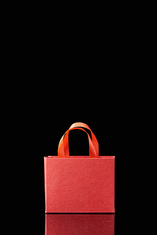 paper red shopping bag with handle isolated on black