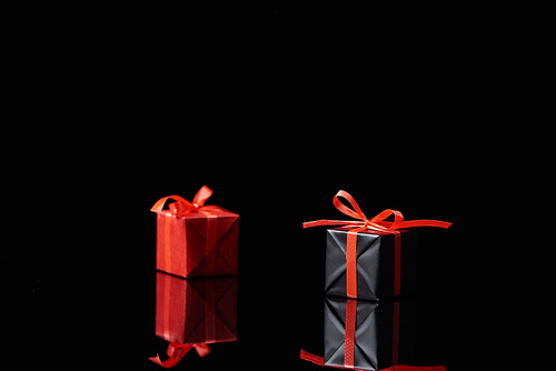selective focus of black and red decorative gifts isolated on black