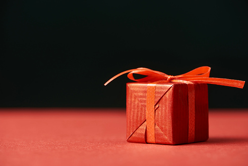 red gift box with ribbon isolated on black with copy space
