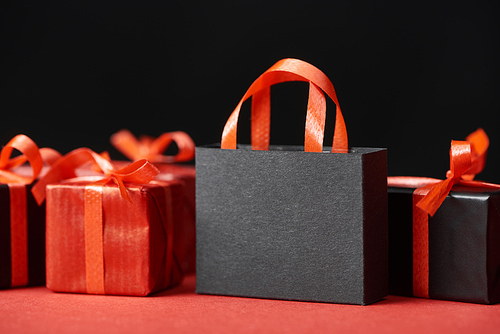 red presents and shopping bag with copy space isolated on black
