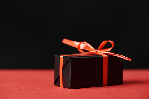 presents with red ribbon and bow isolated on black