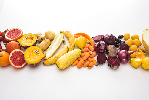 top view of red onions, beetroots, carrots, potatoes, apricots,bananas, zucchini pumpkin and grapefruit on white background