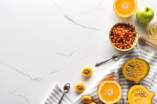 top view of striped towel with pumpkin, apricots, apple and orange near bowl with 씨벅톤 on marble surface