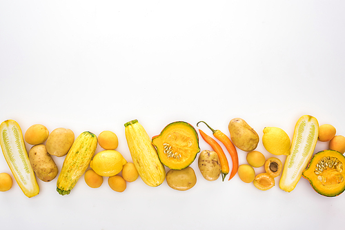 top view of yellow fruits and vegetables on white background