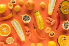 top view of yellow fruits and vegetables on orange background