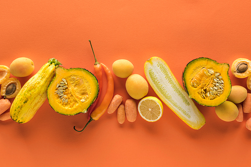 top view of yellow fruits and vegetables on orange background