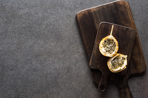 top view of sweet granadilla on wooden cutting boards on grey background