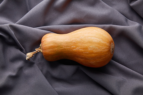 top view of ripe whole pumpkin on grey cloth