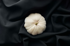 top view of ripe whole white pumpkin on black cloth