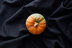 top view of ripe whole colorful pumpkin on black cloth